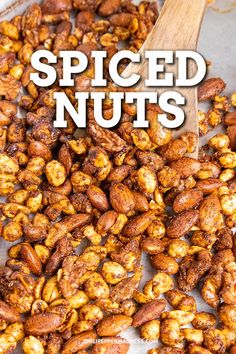 roasted spiced nuts in a pan with a wooden spoon and text overlay that reads spiced nuts