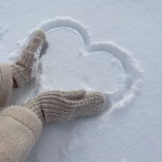 a teddy bear laying in the snow with a heart drawn on it's side