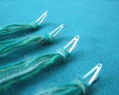 three pairs of scissors sitting on top of green yarn