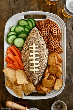 a football platter with crackers, pretzels, cucumbers, carrots and crackers