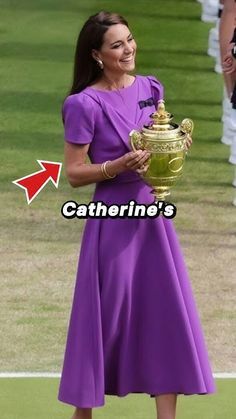 a woman in a purple dress holding a trophy