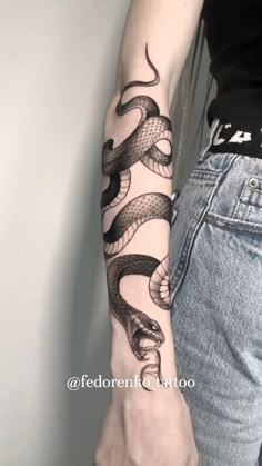 a woman's arm with a snake tattoo on the left side of her arm