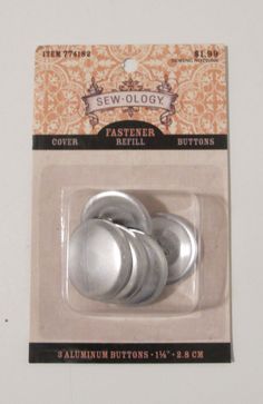 two metal buttons sitting on top of each other in a package with an ad for sew - ollogyy