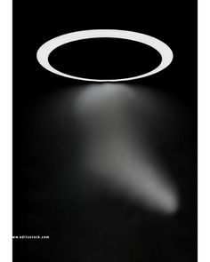 a black and white photo with a circular light on the ceiling in the dark room