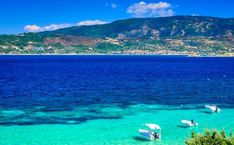 several small boats floating in the clear blue water