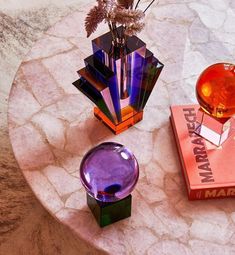 two vases sitting on top of a marble table next to books and a flower