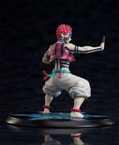 a figurine that is on top of a black surface and has pink hair