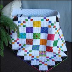 a quilted blanket sitting next to a potted plant