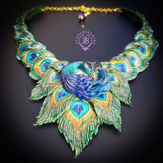 an elaborate necklace with peacock feathers and beads on a black background is featured in this image