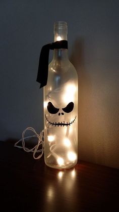 a bottle that has been decorated with lights and a jack skellingy face on it