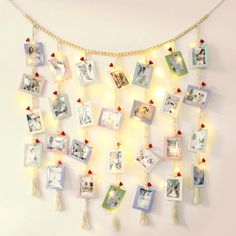 a white wall with pictures and lights hanging from it's sides in the shape of a heart