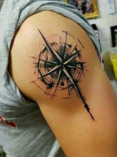 a man with a compass tattoo on his arm