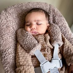 a baby is sleeping in a car seat