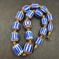 Vinatage Venetian inspired Trade Blue Chevron Glass Beads Necklace NCH-1 Other Names Chevron Beads SIX Layer Type of Object Drawn, multi-layered glass Color BLUE, RED, White  Approximate Age Late 20th century Overall  * Condition: Good to fair.  * See picture with Size measurement tool for size comparison.  * Strand Length24 inches (includes string/raffia) * Brand: Unbranded  * Style: Beaded  * Type: Strand of beads This strand is not intended to be a ready-to-wear necklace. Althou Blue Artisan Jewelry With Colorful Beads, Artisan Blue Jewelry With Colorful Beads, Artisan Blue Jewelry With Large Beads, Elegant Large Blue Beads, Elegant Blue Large Beads, Traditional Glass Bead Jewelry, Blue Bohemian Jewelry With Large Beads, Traditional Oval Beads Glass Jewelry, Artisan Blue Faceted Beads