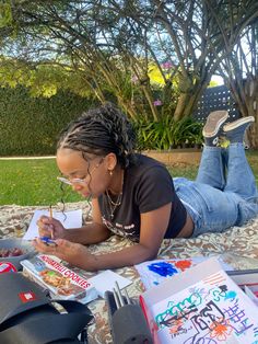 a woman laying on top of a blanket writing