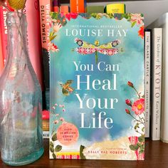 the book you can heal your life by louise hay sits on a bookshelf