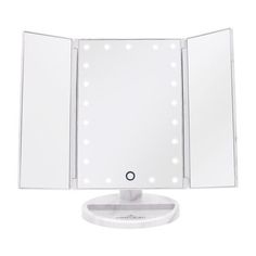 a white lighted vanity mirror on top of a table with an electronic light underneath it