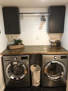 a washer and dryer in a small room with dark wood cabinets on the wall