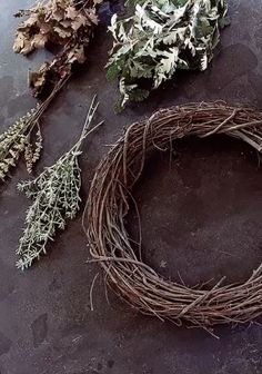 dried herbs are laid out on the ground next to a wreath and twigs for decoration