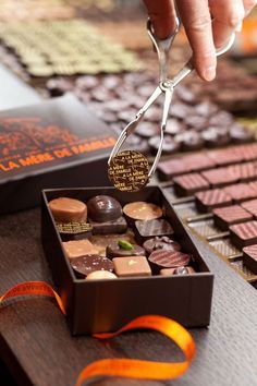 a person is cutting into some chocolates in a box