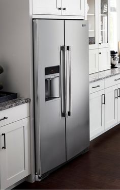 a stainless steel refrigerator in a white kitchen