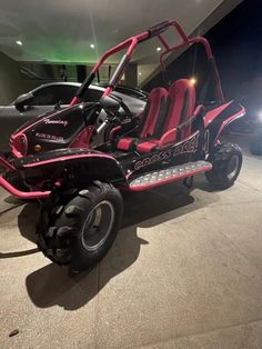 a pink and black buggy is parked in a garage