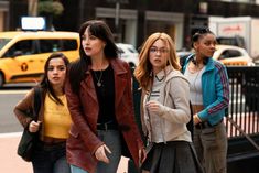 three women are walking down the street together