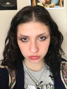 a young woman with dark hair and piercings on her face looking at the camera