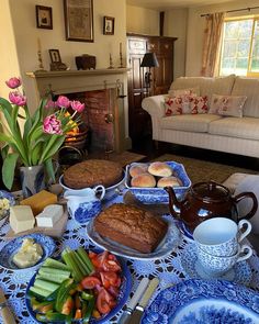 a table filled with food and flowers in front of a fireplace