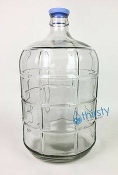 an empty glass bottle with holes in the bottom and blue cap is shown on a white background