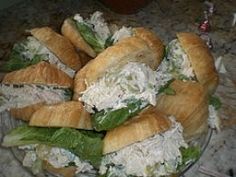 a plate full of croissants with chicken salad on top and lettuce in the middle