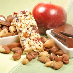 an apple, chocolate bar and nuts on a table