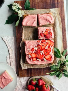 slices of strawberry cake with frosting and fresh strawberries