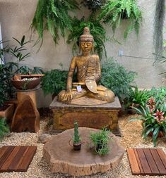 a buddha statue sitting on top of a wooden stump in a garden filled with potted plants