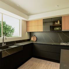 a modern kitchen with black counter tops and wooden cabinets is pictured in this image from the front view