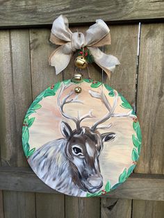 a painted deer ornament hanging on a wooden fence