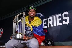 a man sitting on top of a bench holding up a trophy in front of him