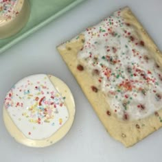 a cookie with sprinkles on it next to an empty plate and tray