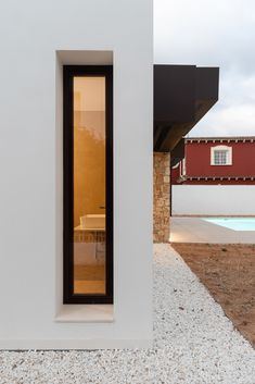 an open door to a house next to a swimming pool with a red building in the background