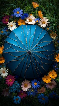 a blue umbrella surrounded by flowers and grass