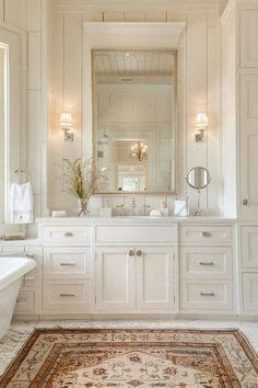 a large bathroom with white cabinets and an area rug