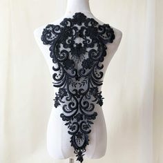 a white mannequin with black lace on it's back and neckline