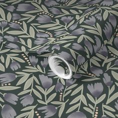 a floral wallpaper with grey and green leaves on black background, including an orange dot