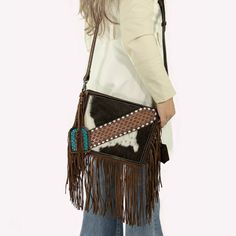 Sun Dance Leather Fringe Crossbody Bag Embrace the spirit of the Wild West with our Sun Dance Leather Fringe Crossbody Bag, where timeless style meets rugged charm. This exquisite bag features a vibrant mix of cowhide and intricate geometric patterns, perfect for those who appreciate unique fashion statements. Compact yet remarkably spacious, this bag is designed for functionality and flair. It's crafted from premium materials that promise durability, ensuring it can withstand the adventures of Western Brown Bag With Adjustable Strap, Western Brown Satchel Shoulder Bag, Western Style Leather Rectangular Shoulder Bag, Western Style Leather Crossbody Bag, Western Style Rectangular Shoulder Bag For Travel, Western Style Brown Satchel Bag, Western Style Rectangular Travel Bag, Western Leather Crossbody Shoulder Bag, Western Leather Crossbody Bag