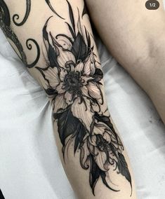 a woman's leg with black and white flowers on it