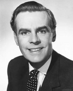 an old black and white photo of a man in a suit smiling at the camera