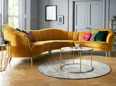 a living room with grey walls and yellow couches in the corner, surrounded by wood flooring