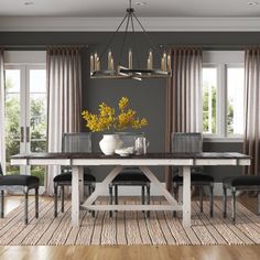 a dining room table with chairs and a vase filled with yellow flowers on top of it