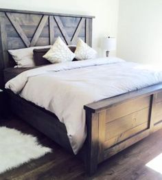 a bed with two pillows on top of it and a wooden headboard in the middle