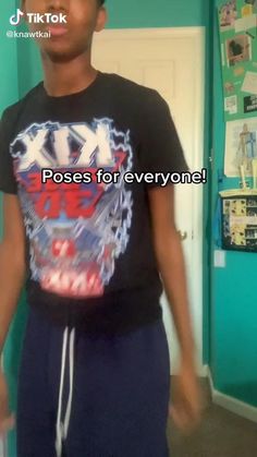 a young man standing in front of a door wearing a t - shirt that says kkd poses for everyone